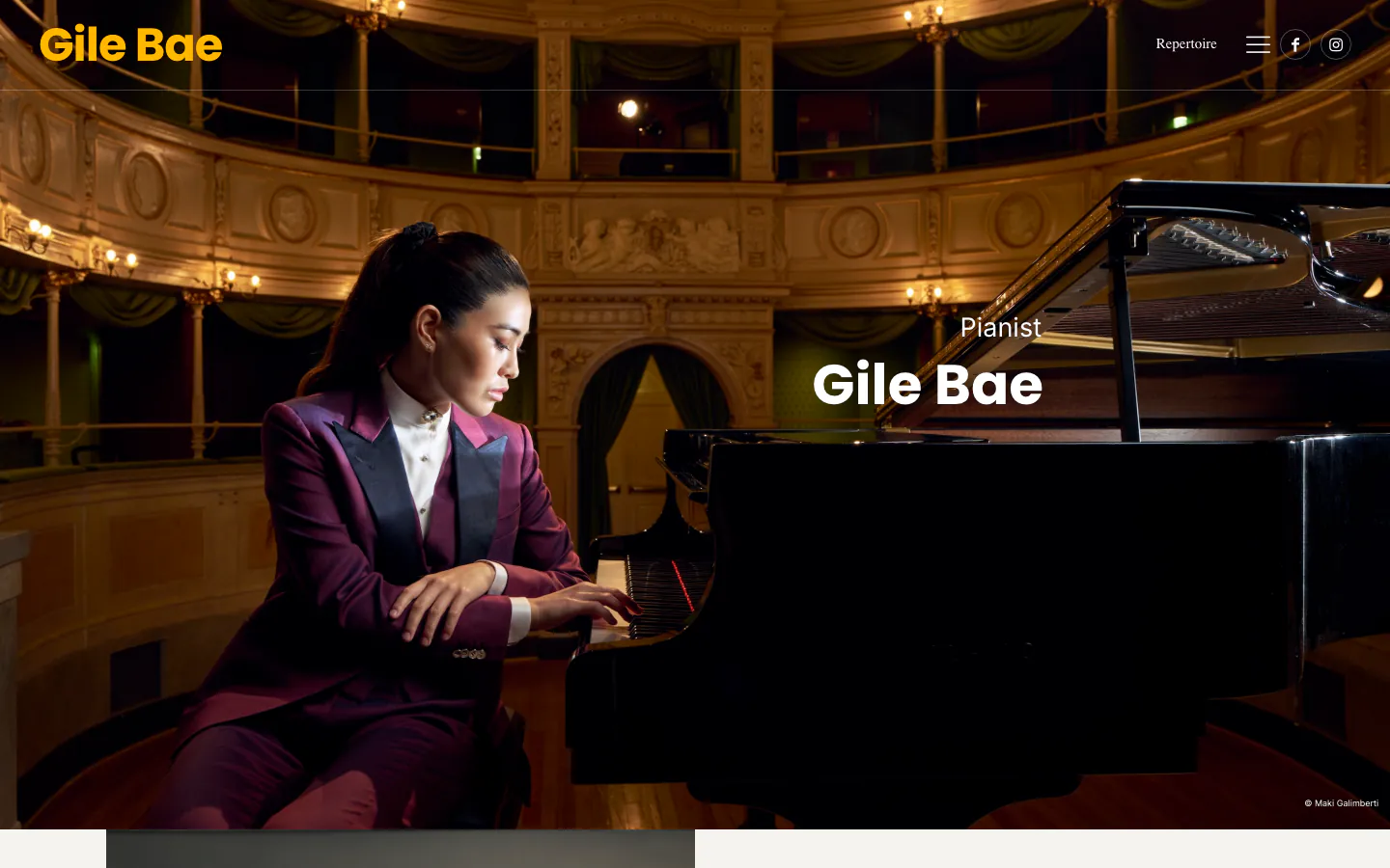 La pianista de concierto Gile Bae sentada a un piano de cola en un teatro.